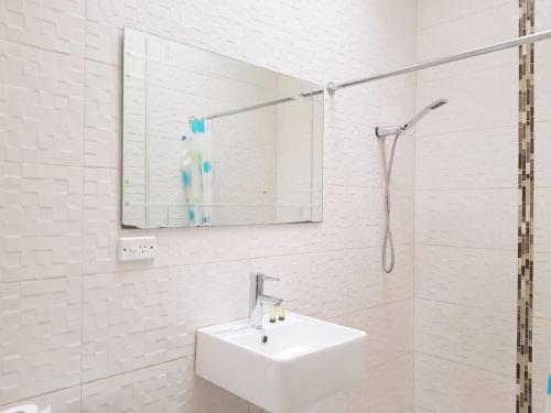 a white bathroom with a sink and a mirror at Perth City Motel in Perth