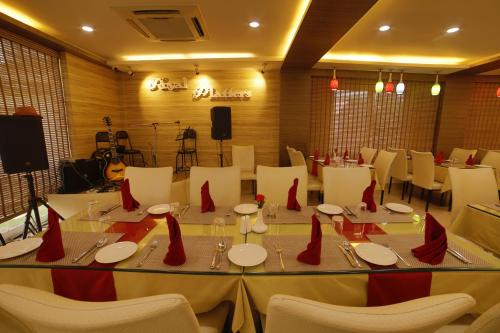 a dining room with white tables and white chairs at Hotel Harrison Palace in Birātnagar