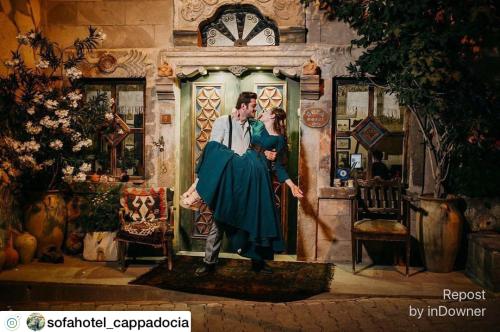 a painting of a couple standing in front of a clock at Sofa Hotel in Avanos