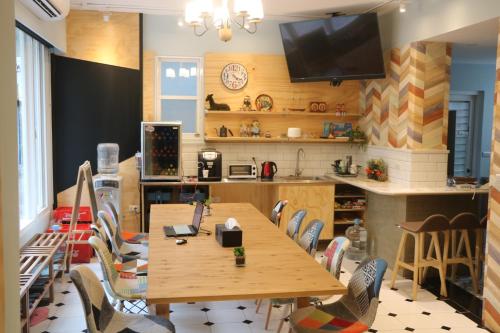 a room with a table and chairs and a kitchen at 愛旅行民宿&近東大門夜市 in Hualien City
