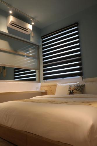 a bedroom with a large bed and a window at 愛旅行民宿&近東大門夜市 in Hualien City