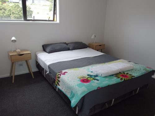Un dormitorio con una cama con una manta. en Ridge View en Wanaka