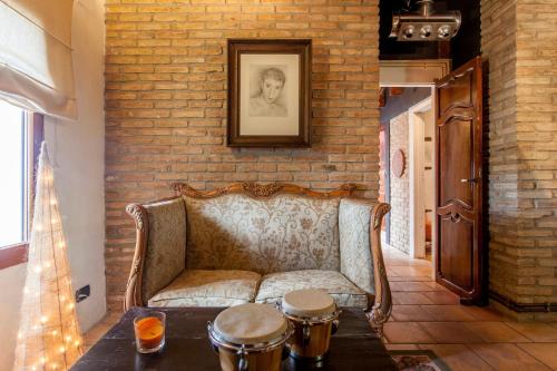 a living room with a couch and a brick wall at Ca Carmela, casa con Encanto con Piscina "Parque Natural Sierra Calderona"cerca Garbi, Good Vives! in Valencia
