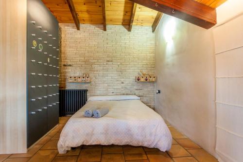 a bedroom with a bed and a brick wall at Ca Carmela, casa con Encanto con Piscina "Parque Natural Sierra Calderona"cerca Garbi, Good Vives! in Valencia