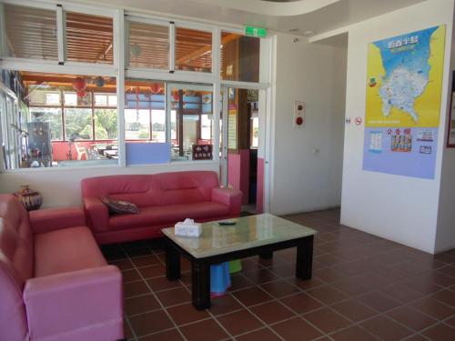 a living room with a red couch and a coffee table at 象樹園農莊特色民宿 in Checheng
