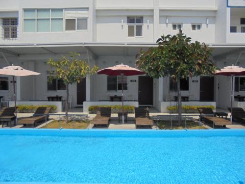 a swimming pool with chairs and umbrellas in front of a building at 象樹園農莊特色民宿 in Checheng