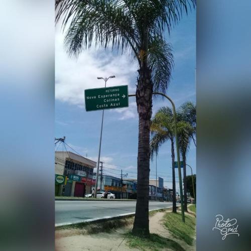 a street sign in front of a palm tree at Menina da Lua in Rio das Ostras