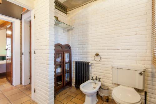 a white bathroom with a toilet and a sink at Ca Carmela, casa con Encanto con Piscina "Parque Natural Sierra Calderona"cerca Garbi, Good Vives! in Valencia