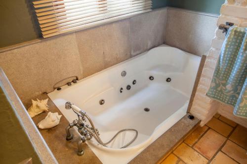 a bath tub in a bathroom with a shower at Ca Carmela, casa con Encanto con Piscina "Parque Natural Sierra Calderona"cerca Garbi, Good Vives! in Valencia