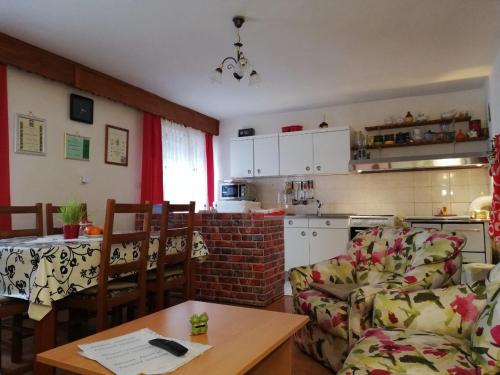 a kitchen and a living room with a couch and a table at Apartment Resman Tršće in Tršće