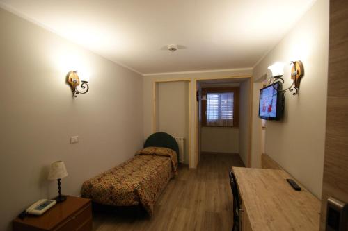 a bedroom with a bed and a table and a tv at Hotel Europa in Bardonecchia