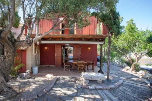 a house with a deck with a table in the yard at Ca Carmela, casa con Encanto con Piscina "Parque Natural Sierra Calderona"cerca Garbi, Good Vives! in Valencia