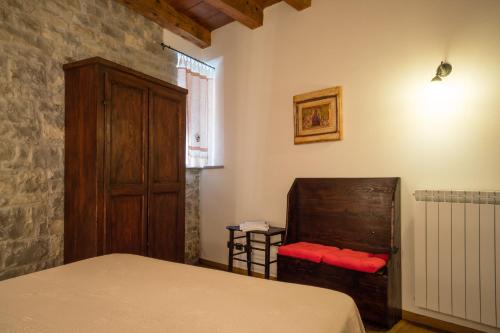 a bedroom with a bed and a wooden cabinet at Borgo San Pietro in Agnone