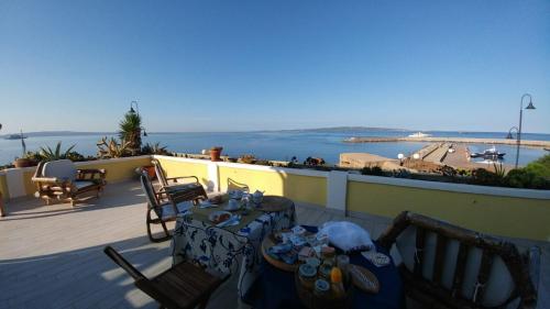 a table and chairs on a balcony with a view of the water at Villarolu in Portoscuso