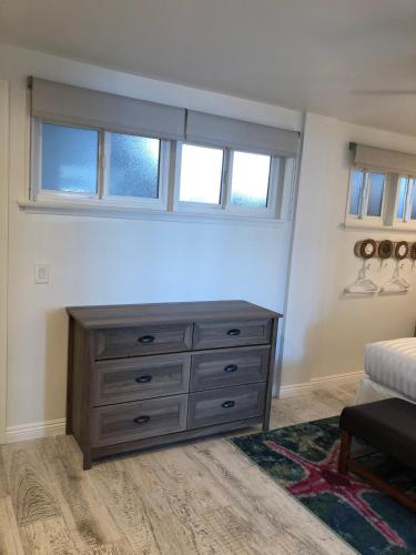 a bedroom with a dresser and two windows at Sea Horse Resort in San Clemente