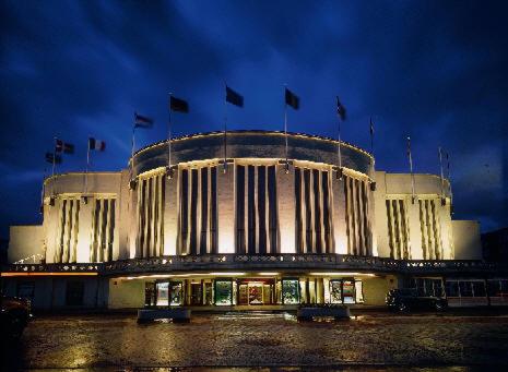 a large building with flags on it at night at Residentie Mariposa in Knokke-Heist
