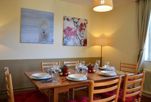 einen Esstisch mit Stühlen und einen Tisch mit Tellern und Gläsern in der Unterkunft Kraxner Haus in Serfaus