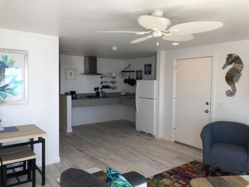 a living room with a ceiling fan and a kitchen at Sea Horse Resort in San Clemente