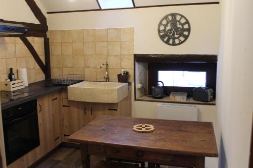 een keuken met een wastafel en een houten tafel bij Les Laurentides in Athée