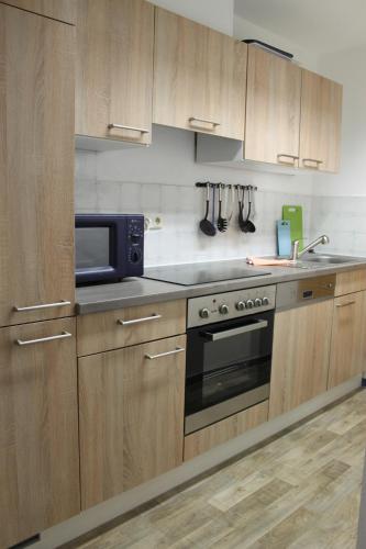 a kitchen with wooden cabinets and a microwave at Lindenhof Habernis in Steinberg