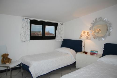 a bedroom with two beds and a mirror on the wall at a 100 metri dal mare in Diano Marina