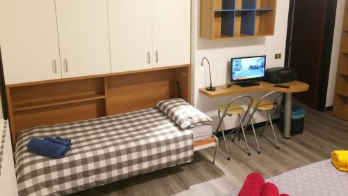 a room with a bed and a desk with a computer at Studio CENTRAL 1 in Aosta