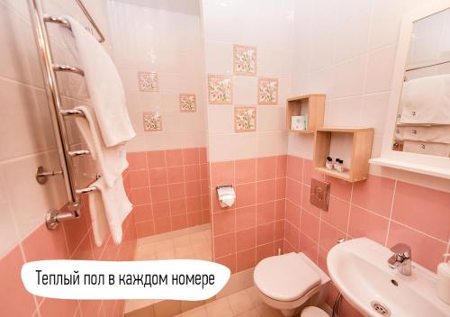 スーズダリにあるDacha Beliy Beregのピンクのバスルーム(トイレ、シンク付)