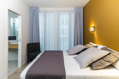 サンティアゴ・デ・コンポステーラにあるHotel Concheirosの大きなベッドとデスクが備わるホテルルームです。