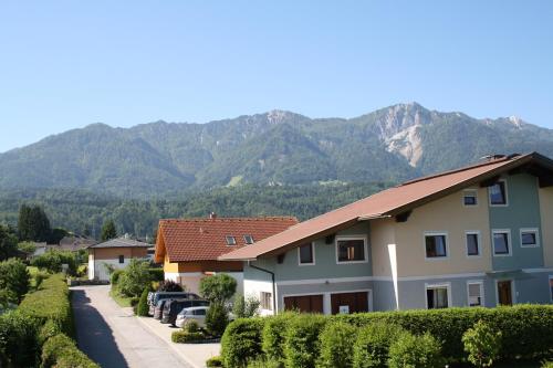 a row of houses with mountains in the background at Pension-Ferienwohnung Rotar in Faak am See