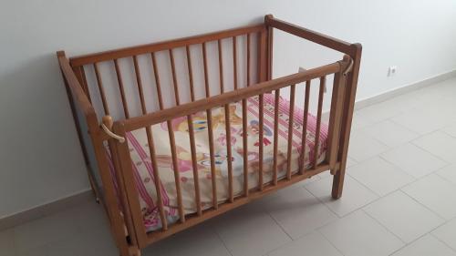 ein Holzbett mit Kinderbett in der Unterkunft Appartement familial spacieux avec climatisation in Ziguinchor