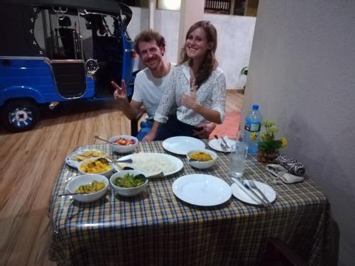 a man and a woman sitting at a table with food at Lasindu Guest in Ahangama