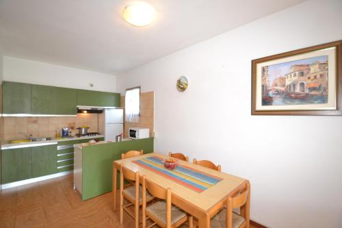a kitchen with a table and chairs in a room at Isotta in Bibione