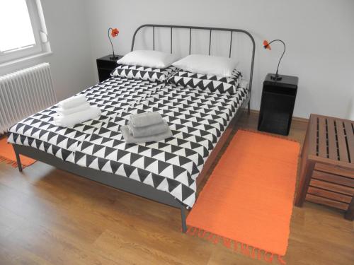 a bedroom with a bed with a black and white comforter at Island View Apartment in Bled