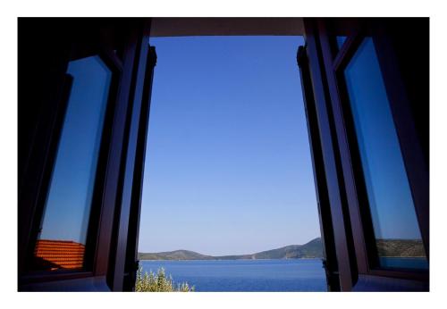 an open window with a view of a body of water at Alonissos beach villa 5 steps away from the sea in Kalamakia