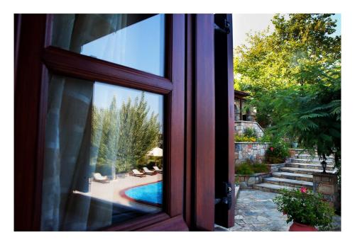 a view of a swimming pool from a window at Alonissos beach villa 5 steps away from the sea in Kalamakia
