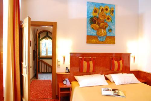 a bedroom with a bed and a painting on the wall at Hotel ZUM TURM in Kaub