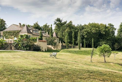 a park bench sitting in a field in front of a house at Maison Manechal in Monfaucon