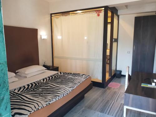 a zebra print bed in a small room at Hotel Milan International in Mumbai