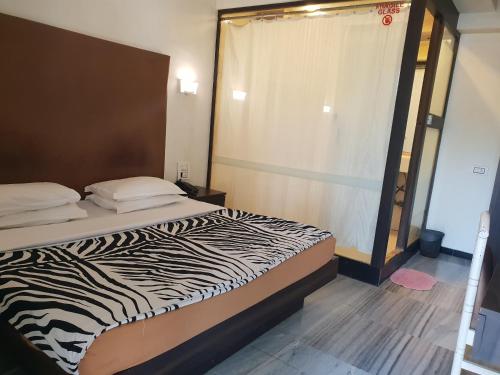 a zebra print bed in a room with a window at Hotel Milan International in Mumbai