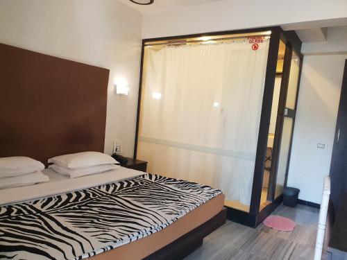 a zebra print bed in a room with a window at Hotel Milan International in Mumbai