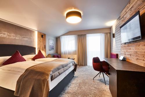 a hotel room with a large bed and a flat screen tv at Der Postwirt in Söll