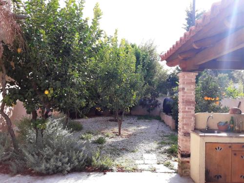 a garden with orange trees and a brick building at Villa Ioanneta in Achladi