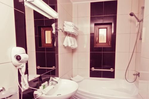 a bathroom with a sink and a toilet and a shower at Hotel Ozana in Bistriţa