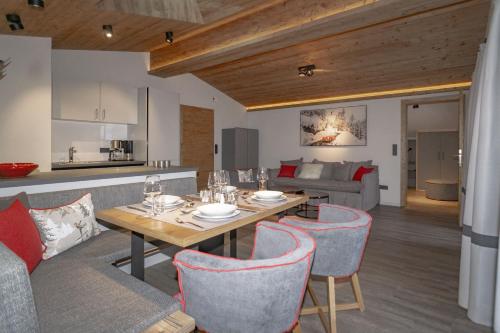 a dining room and living room with a table and chairs at Appartements Erwin & Eleonore Hüttl - Penthouse in Neukirchen am Großvenediger