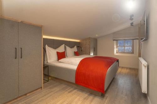 a bedroom with a large bed with red pillows at Appartements Erwin & Eleonore Hüttl - Penthouse in Neukirchen am Großvenediger