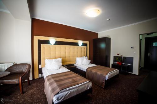a hotel room with two beds and a couch at Hotel Ozana in Bistriţa