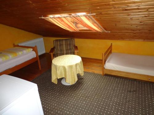 a room with two beds and a table and a chair at Pension Schamberger in Neukirchen beim Heiligen Blut