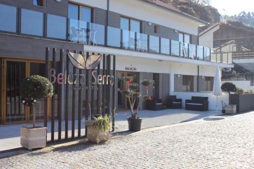 a building with a gate with plants in front of it at Beleza Serra Guide Hotel in Geres