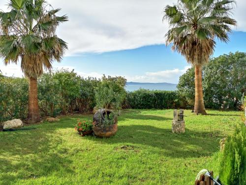 a yard with palm trees and flowers on the grass at Kanalli Apartments in Pomos