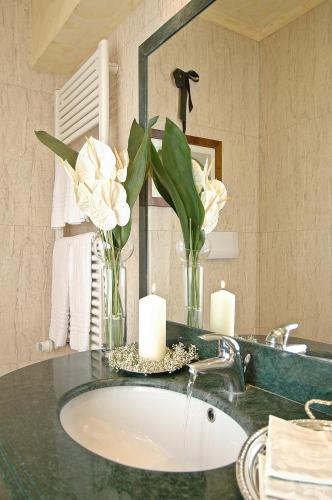 a bathroom with a sink with two candles and flowers at Palazzo Odoni in Venice
